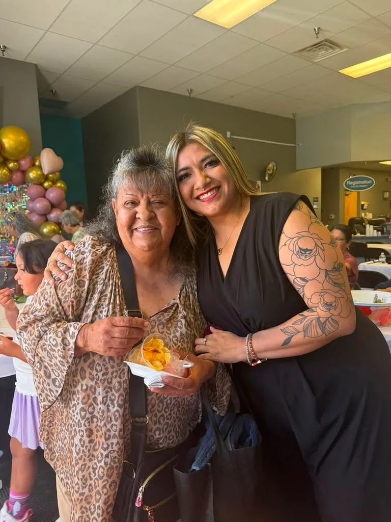 Un abrazo cálido con una clienta mayor en la oficina de El Paso